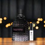 perfume valentino junto a su decant sobre piso de madera
