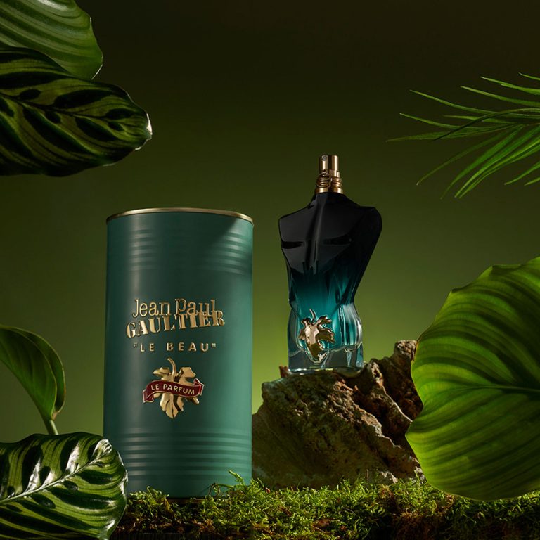 perfume le beau le parfum junto a su frasco sobre fondo verdoso